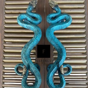 Pu&ograve; includere: Un paio di maniglie per porte a forma di serpente blu e oro. Le maniglie sono in metallo e presentano un design di serpente realistico. I serpenti sono arrotolati in modo da sembrare pronti a colpire. Le maniglie sono un'aggiunta unica ed elegante a qualsiasi casa.