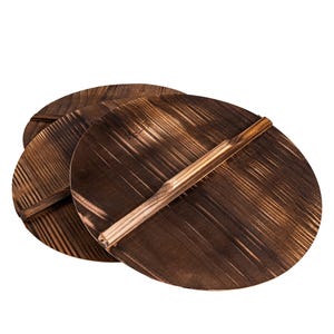 May include: Three round wooden lids with a brown wood grain pattern and a wooden handle. The lids are stacked on top of each other.