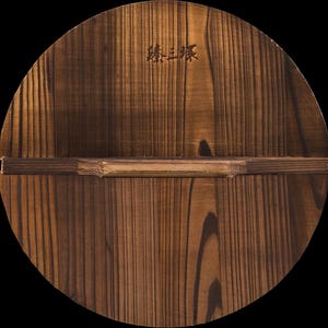 May include: A round wooden lid with a dark brown finish. The lid has a wooden handle and a label with the text "熱上菜" in Japanese.