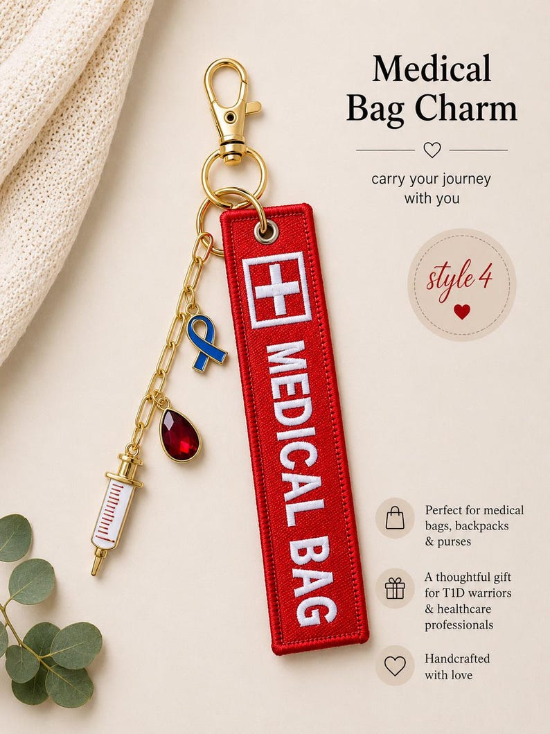 May include: A red rectangular embroidered fabric tag with the white text MEDICAL BAG and a white cross symbol. It features a gold-tone lobster clasp, a gold chain, a blue ribbon charm, a red teardrop charm, and a white and gold syringe charm.