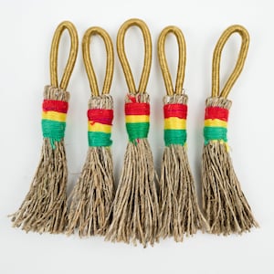 May include: Five small, brown, woven, tassel-like ornaments with gold loops and red, yellow, and green stripes.