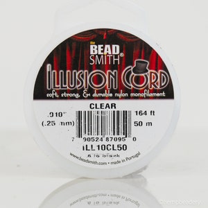 May include: A spool of clear Illusion Cord beading thread by The Bead Smith. The label reads "Illusion Cord, soft, strong, & durable nylon monofilament, Clear, .010" (.25 mm), 164 ft, 50 m, ILL10CL50, 8 lb break, www.beadsmith.com, made in Portugal".