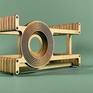 May include: A wooden shelf unit with a circular design in the centre. The shelf is made of plywood and has a natural wood finish.