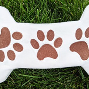 DIY dog bone toy embroidery design with paw prints.