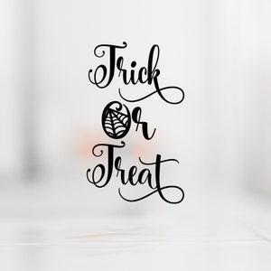 May include: Black and white calligraphy text that reads "Trick or Treat" with a stylised spiderweb graphic between the words "Trick" and "Treat".