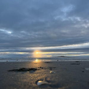 Op de afbeelding: Een set van drie keramische mokken met een gespikkelde, matte afwerking. De mokken zijn in de kleuren crème, lichtgrijs en donkergrijs. Elke mok heeft een eenvoudig, minimalistisch ontwerp en een afgeronde handgreep.