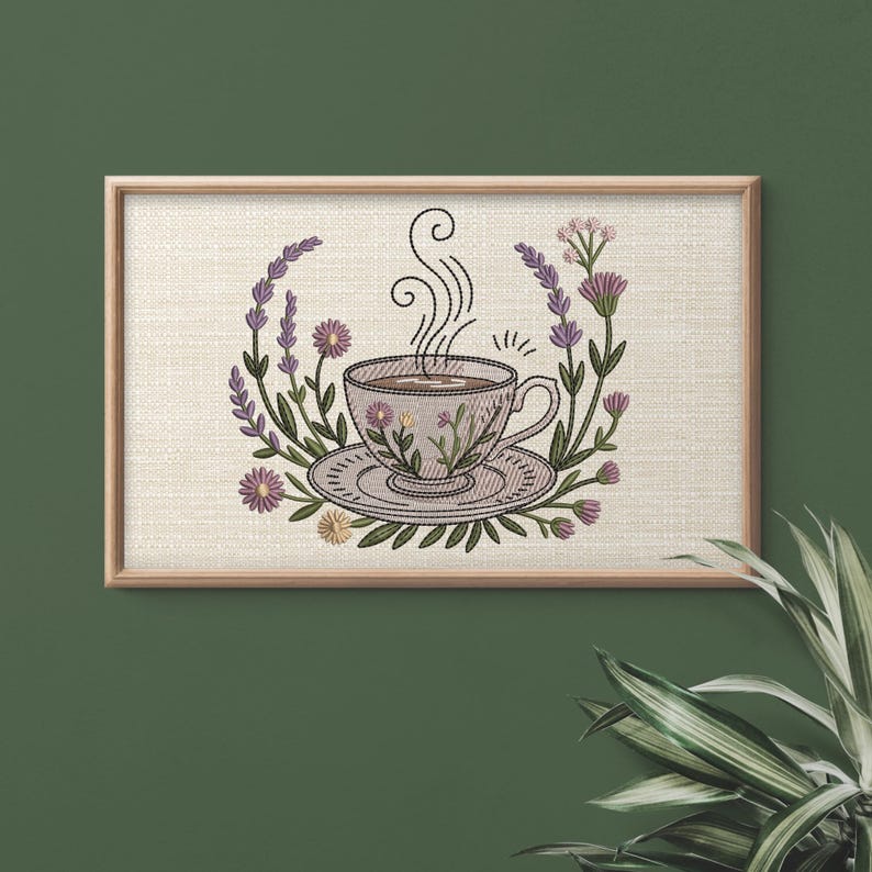 May include: Embroidered artwork of a teacup and saucer with steam rising, surrounded by purple and green floral elements. The teacup and saucer are light purple with floral designs. The artwork is framed in a light brown wooden frame.