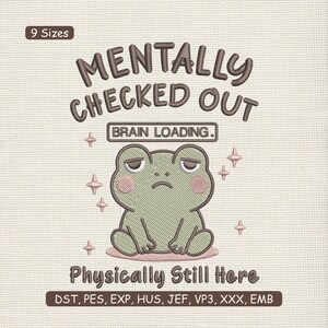 May include: An embroidered design featuring a cartoon frog with a sad expression. The text reads "MENTALLY CHECKED OUT" above and "Physically Still Here" below, with "BRAIN LOADING" in between. The design includes pink accents and star shapes.