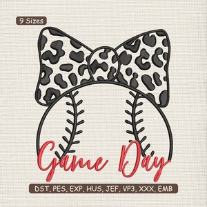 Puede incluir: Un diseño de bordado con una pelota de béisbol con costuras negras y las palabras "Game Day" en escritura roja. Un lazo con estampado de animales en blanco y negro se encuentra encima de la pelota. El diseño está disponible en 9 tamaños.