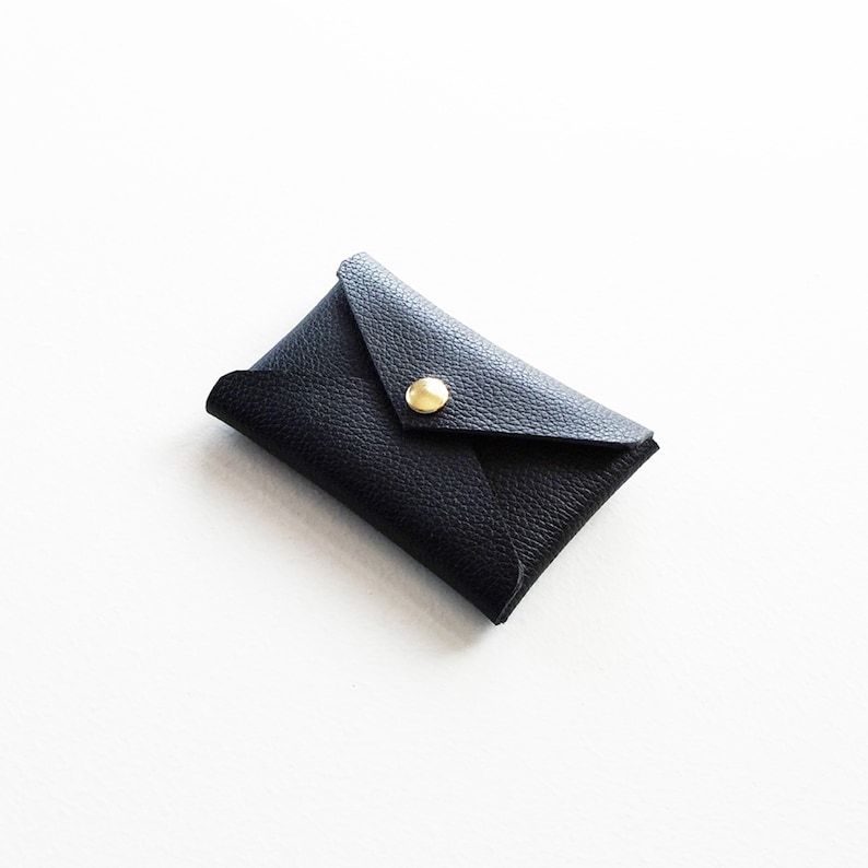 Angled top view of black leather envelope style credit card case.
