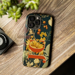 Personalized vintage Autumn floral pattern iPhone Tough case with large initials on desktop.