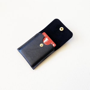 Leather keychain snap closure credit card wallet open with credit cards inside.