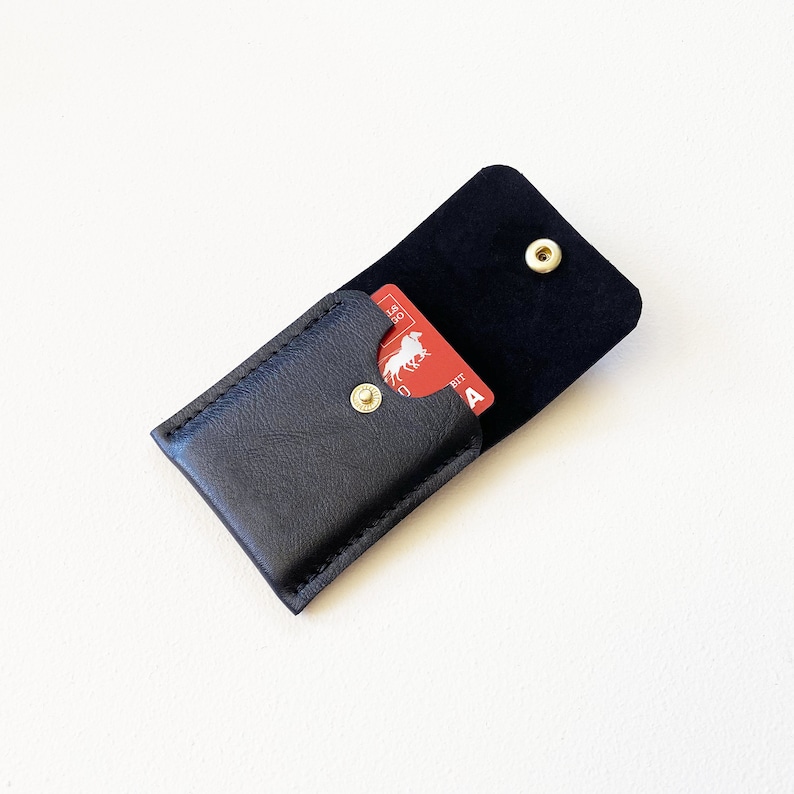 Leather keychain snap closure credit card wallet open with credit cards inside.