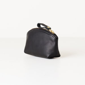 Small leather clutch on tabletop.