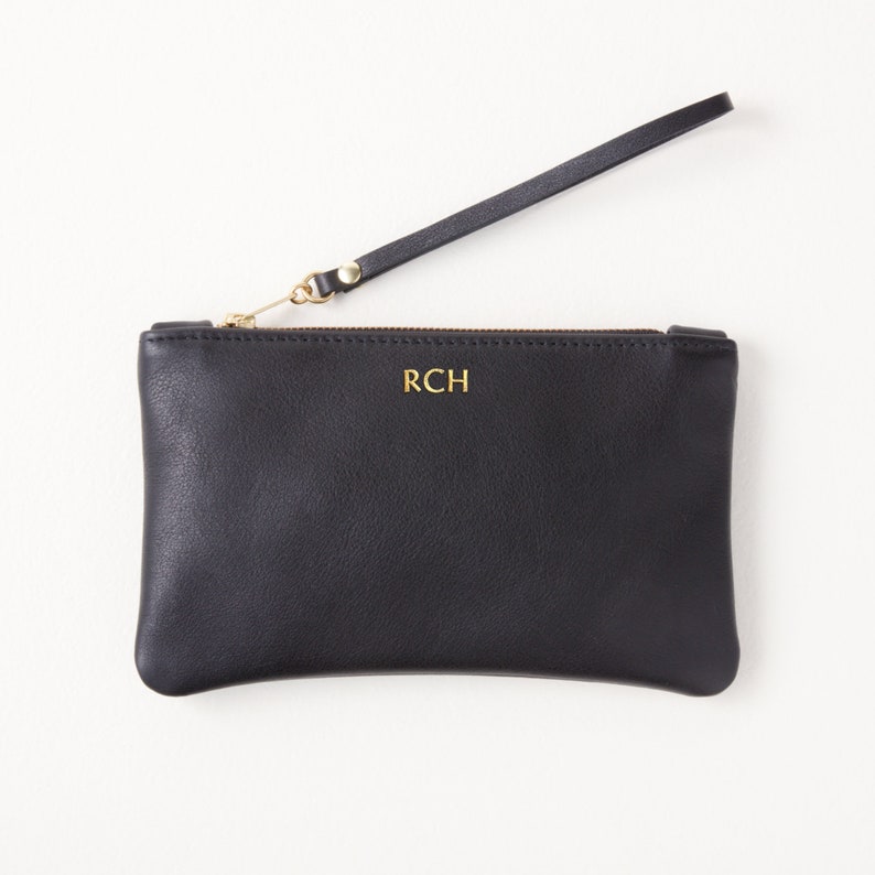 Monogrammed leather clutch with wrist strap top view.