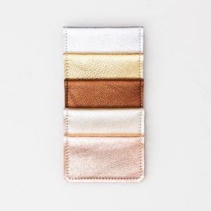 Set of five metallic leather credit card wallets in a variety of colors.