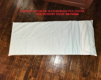 May include: A white rectangular pillow cover, possibly cotton or waterproof PUL, for memory foam or foam pillows. The cover is laid out on a dark wood surface. Text in red reads "COTTON COVER OR WATERPROOF PUL COVER FOR MEMORY FOAM OR FOAM."