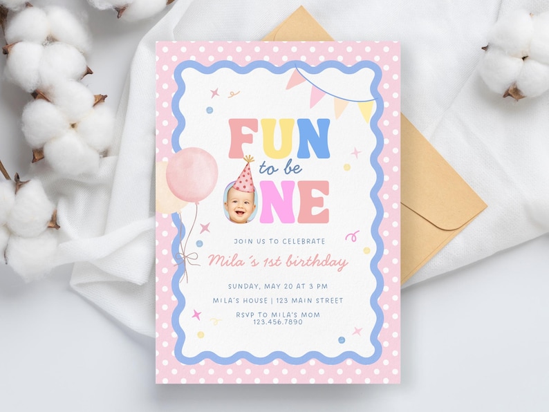 Może przedstawiać: Pastelowe r&oacute;żowe i niebieskie zaproszenie urodzinowe z napisem "FUN to be ONE". Zaproszenie zawiera zdjęcie dziecka w czapeczce urodzinowej, r&oacute;żowy balon i elementy dekoracyjne. Zaproszenie jest na 1. urodziny Mili.