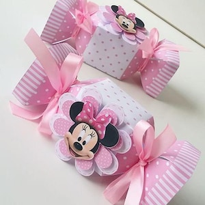 Pode incluir: Caixas de doces rosa e branco com um design de Minnie Mouse. As caixas s&atilde;o decoradas com bolinhas e listras. Cada caixa tem uma fita rosa amarrada ao redor.