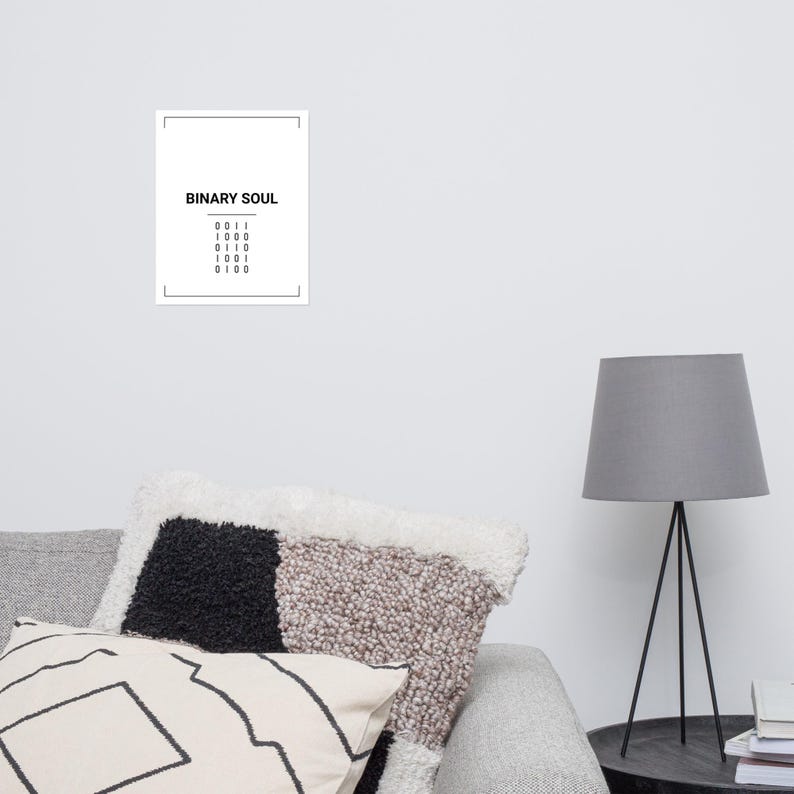 May include: A rectangular white wall art print featuring the black text BINARY SOUL centered at the top, followed by five rows of four-digit binary code numbers, all enclosed within a thin black rectangular border frame on a white background.