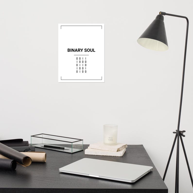 May include: A rectangular white wall poster featuring the black text BINARY SOUL centered at the top, followed by a horizontal line and five rows of binary code digits consisting of zeros and ones, all enclosed within a thin black rectangular border.