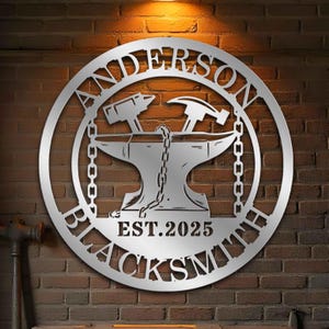 Pode incluir: Placa de metal prateada com o texto "Anderson Blacksmith Est. 2025" e uma silhueta de uma bigorna com um martelo e tenazes.
