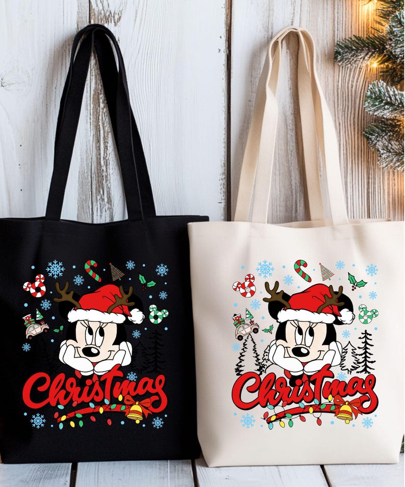 Puede incluir: Dos bolsas de mano, una negra y otra blanquecina, presentan un dise&ntilde;o de Minnie Mouse con tem&aacute;tica navide&ntilde;a. El dise&ntilde;o incluye copos de nieve, bastones de caramelo y la palabra "Christmas" en escritura roja. Las bolsas tienen asas negras.