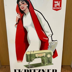 May include: Vintage metal sign featuring a woman in a white dress and red cape, with a green sewing machine. The sign has the brand name "GRITZNER" and the text "TKPITZNEP" at the bottom.