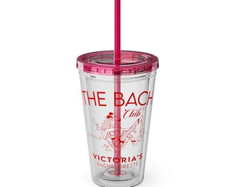 May include: A clear plastic tumbler with a pink lid and straw. The tumbler has a red graphic that says "The Bach Club" and features a woman in a dress and hat. The text "Victoria's Bachelorette" is also printed on the tumbler.