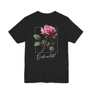 May include: Black t-shirt with a pink rose graphic and the text "Dedicated!" printed on the back.