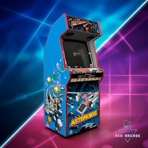 May include: A blue arcade cabinet featuring the game "Asteroids." The cabinet has a red trim and a black screen displaying game instructions. The cabinet art depicts spaceships, asteroids, and the game's logo. The top of the cabinet has a graphic of a space battle.