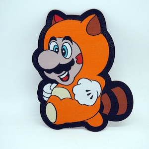 May include: A cartoon character wearing an orange raccoon costume with a black outline. The character has a brown mustache and a white glove on its right hand.