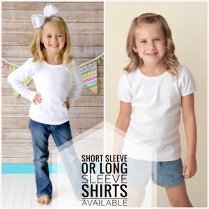Puede incluir: Dos ni&ntilde;as peque&ntilde;as con camisetas blancas, una de manga larga y otra de manga corta. Ambas ni&ntilde;as llevan pantalones vaqueros azules. El texto "SHORT SLEEVE OR LONG SLEEVE SHIRTS AVAILABLE" se muestra debajo de las ni&ntilde;as.