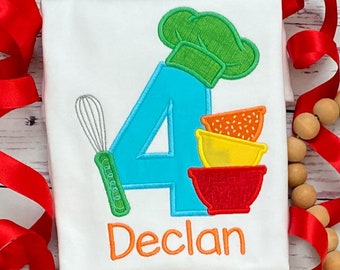 May include: A white t-shirt with a blue number four, a green chef's hat, a red, yellow, and orange mixing bowl, a green whisk, and the name "Declan" in orange.