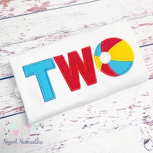 May include: White t-shirt with the word "TWO" in red, blue, and white letters with a red, yellow, and blue beach ball to the right of the word.