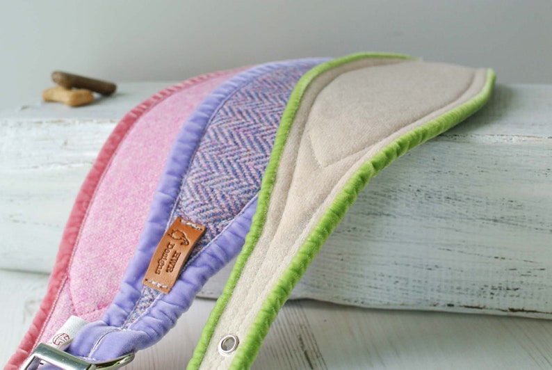 May include: Three dog collars in different colors and patterns. The collars are made of soft fabric and have a padded lining. The collars are lined with green, pink, and purple velvet. The collars have a brown leather tag with the text "The Doggy" on it.