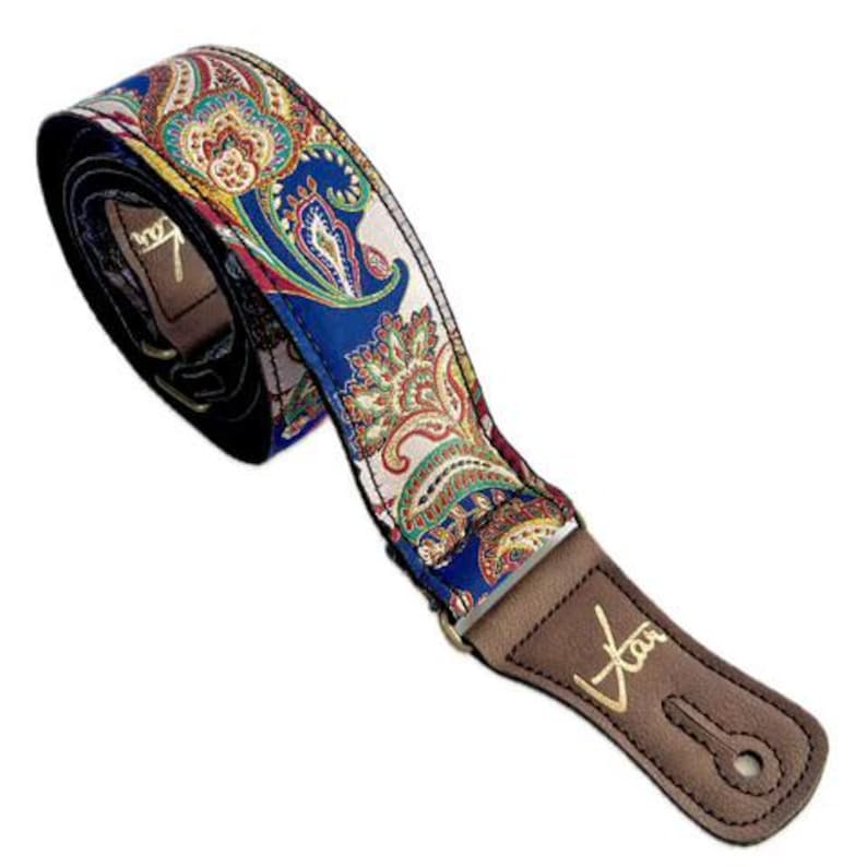 May include: A guitar strap featuring a vibrant paisley design in shades of blue, red, yellow, and green. It has a brown leather end with gold lettering and a keyhole for securing it.