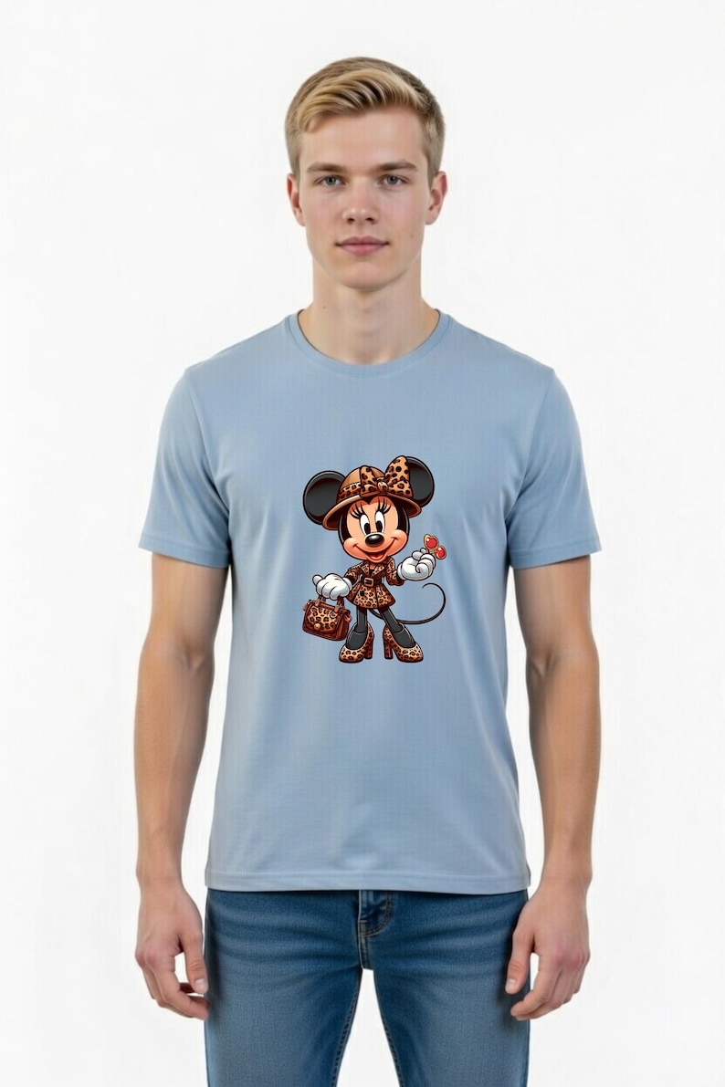 May include: Light blue t-shirt featuring a cartoon Minnie Mouse character in a stylish outfit. Minnie is wearing a leopard print hat, coat, and shoes, carrying a matching purse, and holding a red butterfly. The shirt is worn by a person.