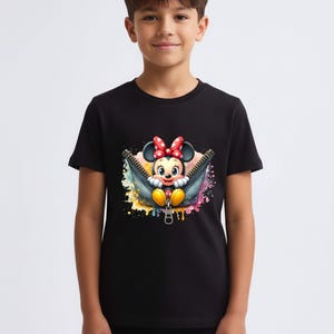 May include: Black t-shirt featuring a colorful graphic of Minnie Mouse emerging from a zipper. Minnie Mouse is wearing a red bow and yellow shoes. The background has colorful paint splatters. The shirt is worn by a young person.