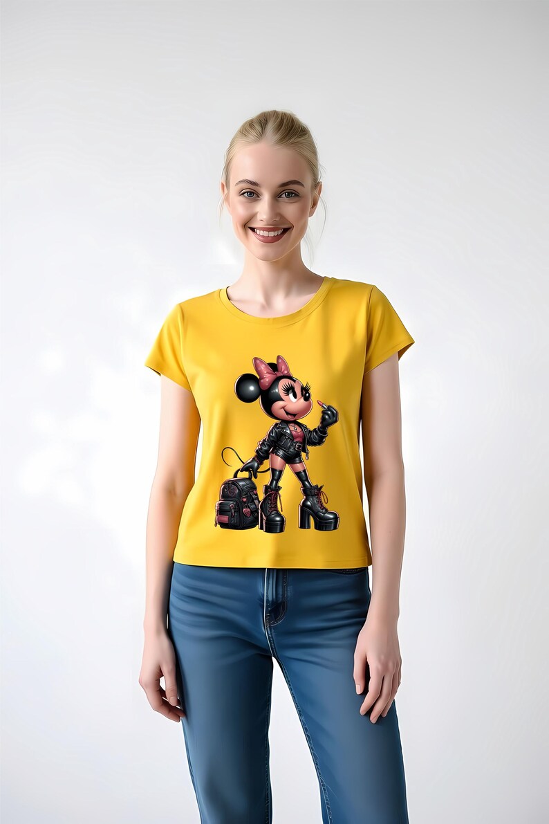 Peut inclure: T-shirt jaune moutarde avec un dessin de souris de dessin anim&eacute; portant une veste en cuir noire, des bottes et un sac &agrave; dos. La souris a un n&oelig;ud rose et tient une cigarette. Le t-shirt est port&eacute; avec un jean bleu.