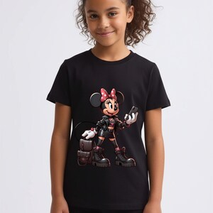 Peut inclure: T-shirt noir avec un dessin anim&eacute; de Minnie Mouse portant une veste noire, des bottes et un sac &agrave; dos. Minnie tient un t&eacute;l&eacute;phone et porte un n&oelig;ud rouge. Le fond est blanc.