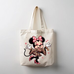 May include: A cream-colored tote bag featuring a cartoon illustration of Minnie Mouse. Minnie is wearing a leopard print outfit, pink heels, and a pink polka dot bow. The design includes pink star accents.