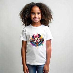 May include: White t-shirt featuring a colorful graphic of Minnie Mouse peeking out of a zipper. The design includes a pink bow, and the zipper is surrounded by paint splatters. The shirt is worn by a young girl.