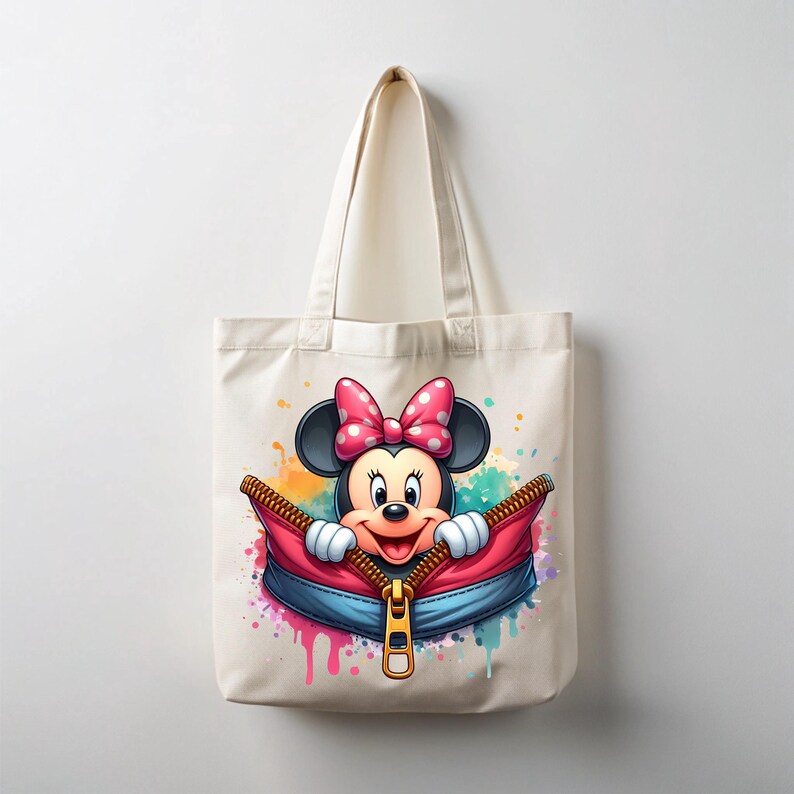 May include: A cream-colored tote bag featuring a colorful illustration of Minnie Mouse. Minnie Mouse is peeking out of a red and blue zipper, with a pink bow and white polka dots. The bag has a simple design with a handle.