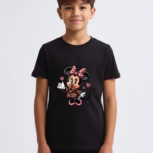May include: Black t-shirt featuring a Minnie Mouse graphic. Minnie is wearing a bow, dress, and shoes with a pink and red heart pattern. The shirt is short-sleeved and has a crew neck.