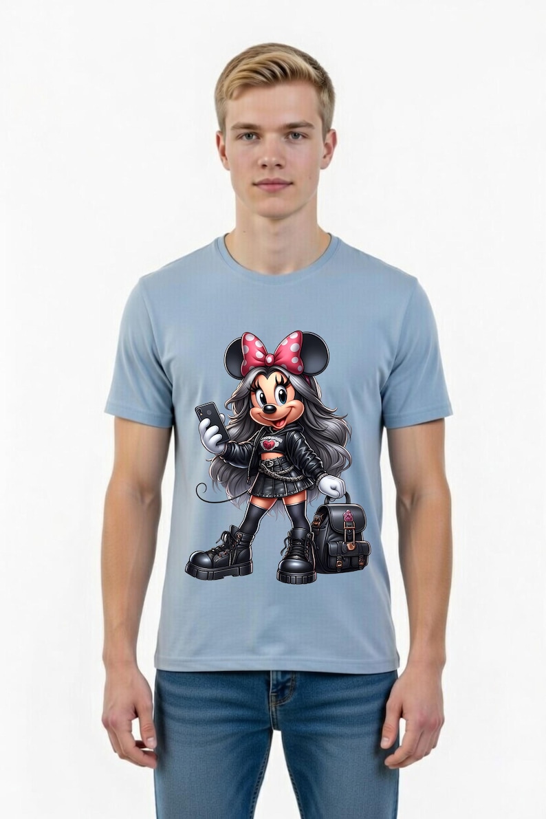 Peut inclure: T-shirt bleu clair avec une illustration de Minnie Mouse en tenue noire, tenant un t&eacute;l&eacute;phone et un sac &agrave; dos. Minnie Mouse porte un n&oelig;ud rose &agrave; pois blancs. Le t-shirt est port&eacute; par une personne.