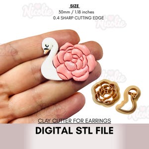 Op de afbeelding: Een roze en witte klei-oorbel met een zwaan- en bloemontwerp, vastgehouden in een hand. De afbeelding toont ook de kleisnijgereedschappen. De tekst op de afbeelding luidt "CLAY CUTTER FOR EARRINGS" en "DIGITAL STL FILE". De grootte is 30 mm.
