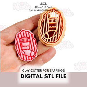 May include: A tan and red clay cutter for earrings shaped like a Christmas stocking. The cutter is 40mm in size and has a sharp cutting edge. The text "CLAY CUTTER FOR EARRINGS" and "DIGITAL STL FILE" are also visible.