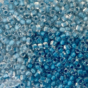 May include: A set of three ceramic mugs with a speckled, matte finish. The mugs are in shades of cream, light gray, and dark gray. Each mug has a simple, minimalist design and a rounded handle.