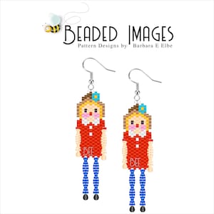 Könnte beinhalten: Ein Paar Perlen-Ohrhänger mit einem Puppen-Design. Die Puppen haben blondes Haar, rote Kleider und blaue Beine. Jeder Ohrring hat einen silbernen Haken und das Wort "BEE" steht auf dem Kleid.